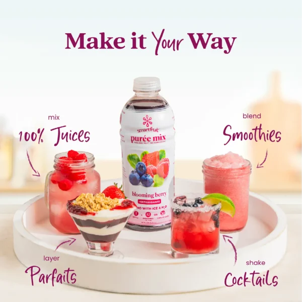 A Smartfruit Blooming Berry purée mix bottle displayed on a white tray surrounded by berry drinks and desserts including juice, a parfait, a smoothie, and a cocktail. Text highlights different uses: 100% juices, parfaits, smoothies, and cocktails.