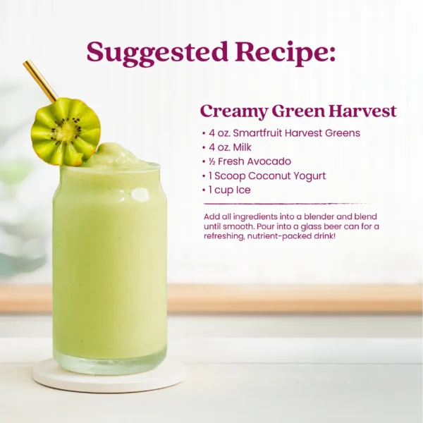 A creamy green smoothie served in a glass can-shaped cup garnished with a kiwi slice. Text shows a suggested recipe for a Creamy Green Harvest made with Smartfruit Harvest Greens, milk, avocado, coconut yogurt, and ice, with instructions to blend until smooth.