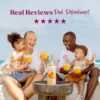 A smiling family sitting outdoors near the ocean enjoys mango smoothies together while a bottle of Smartfruit Mellow Mango purée mix sits on a table in front of them. Text above reads “Real Reviews, Real Refreshment” with five stars.