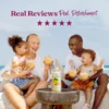 A smiling family sitting outdoors near the ocean enjoys banana smoothies together while a bottle of Smartfruit Sunny Banana purée mix sits on a table in front of them. Text above reads “Real Reviews, Real Refreshment” with five stars.