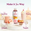 A Smartfruit Strawberry Bananza purée mix bottle displayed on a white tray surrounded by strawberry banana desserts and drinks including smoothies, milkshakes, parfaits, and ice cream. Text highlights different uses: smoothies, shakes, desserts, and parfaits.