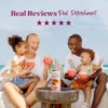 A smiling family sitting outdoors near the ocean enjoys strawberry smoothies together while a bottle of Smartfruit Strawberry Bananza purée mix sits on a table in front of them. Text above reads “Real Reviews, Real Refreshment” with five stars.