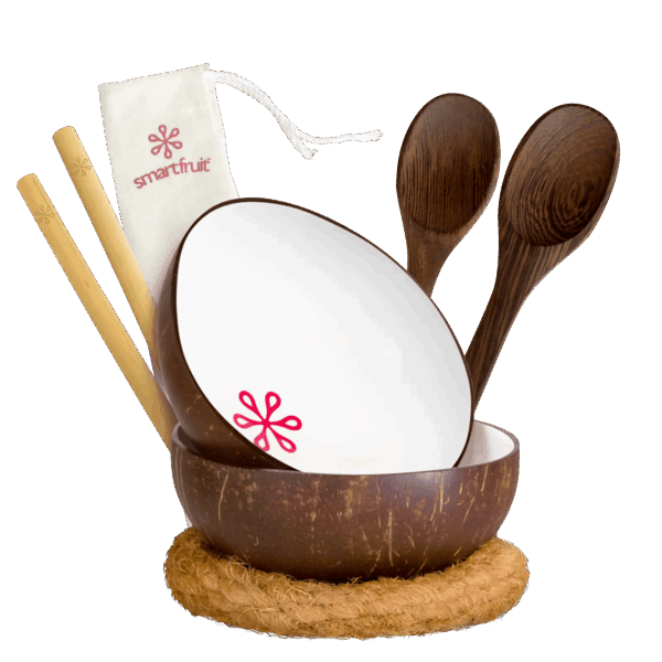 White coconut bowl set including bamboo straws, fiber rings, wooden spoons, and pouch